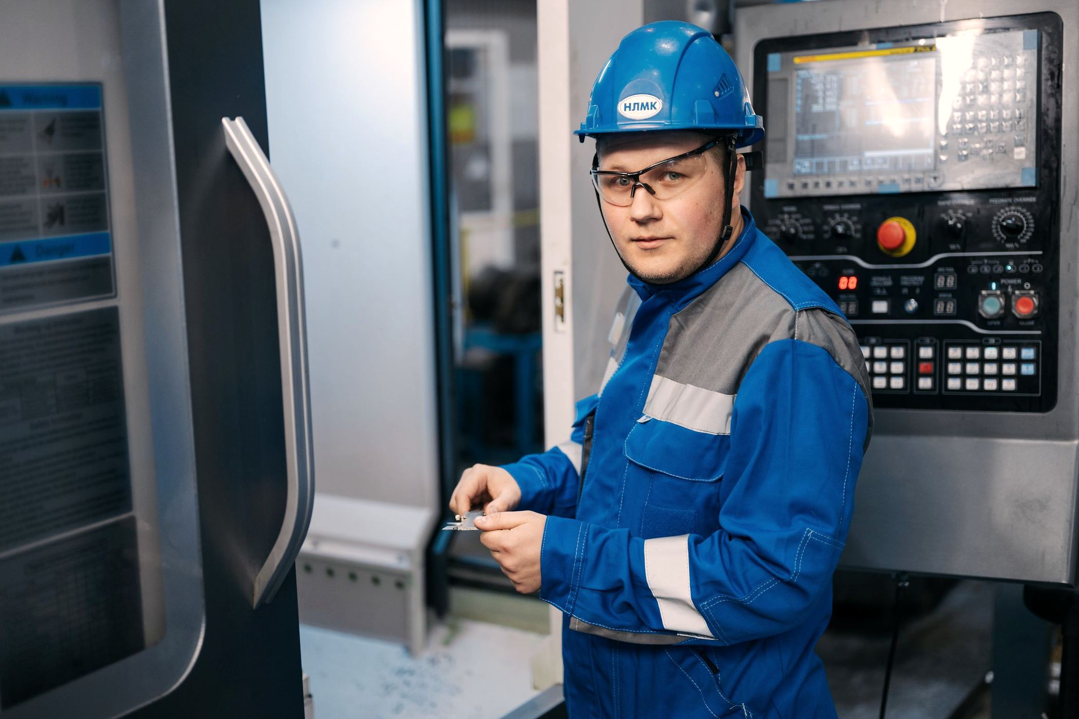 An engineer operating a CNC machine in a modern factory