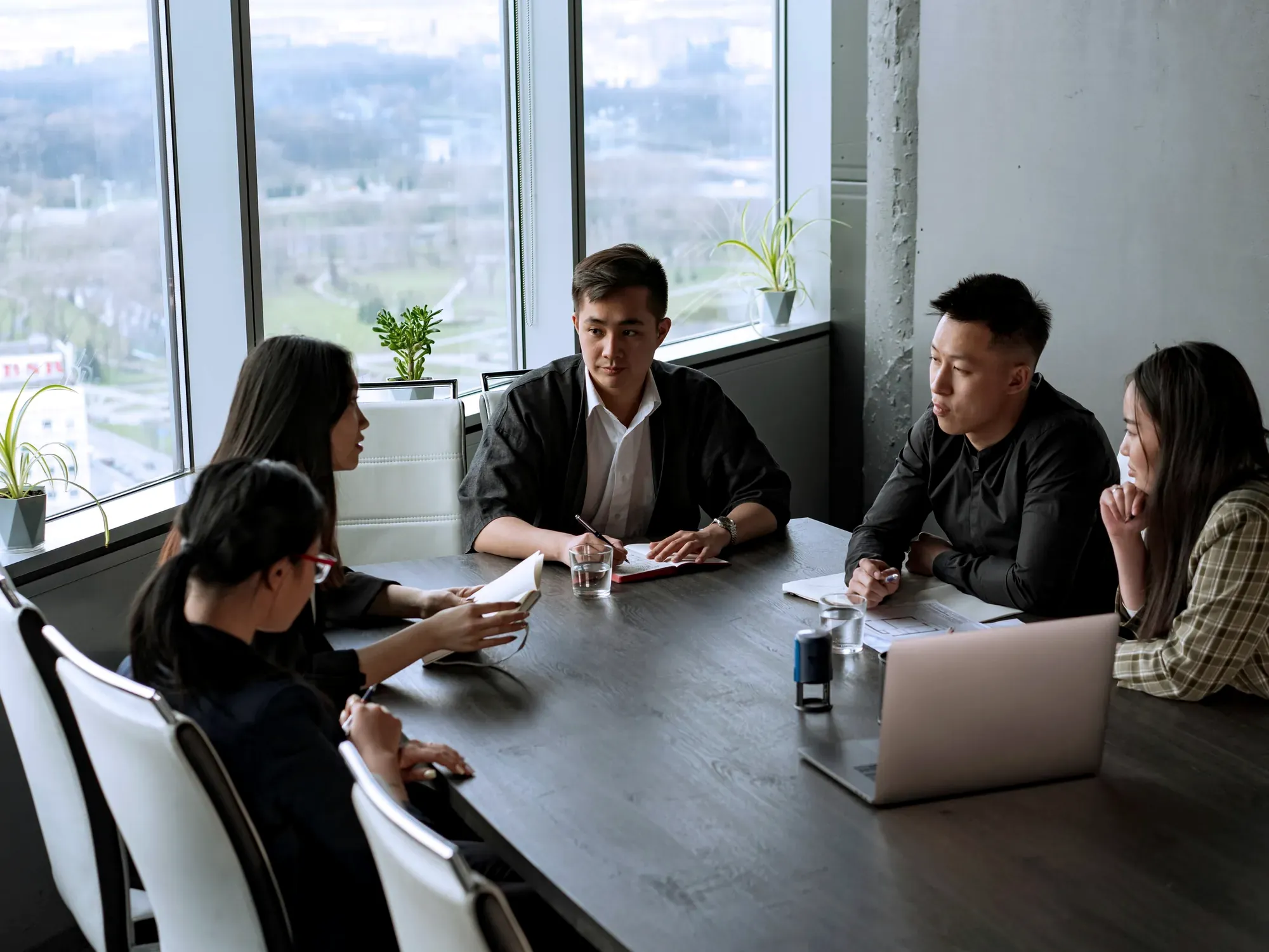 A diverse team reviewing work together on a laptop in a modern office